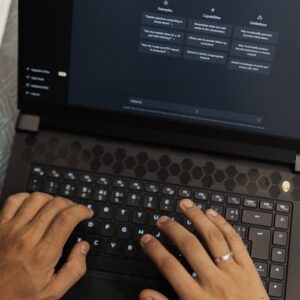 Hands typing on a laptop displaying the ChatGPT interface, showcasing AI technology.