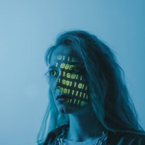 Stylized portrait of a woman with binary code projected on her face, evoking themes of technology and identity.