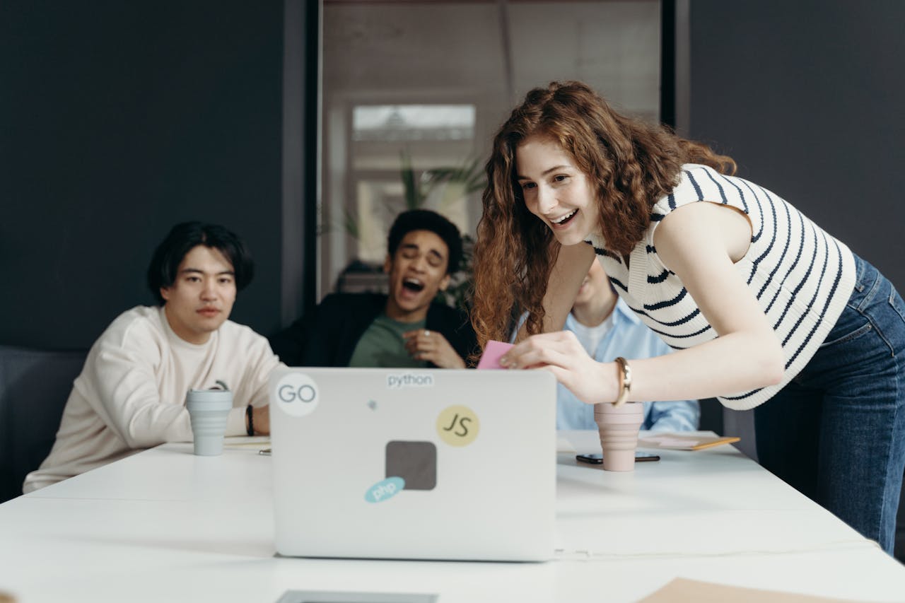 A diverse group of young professionals collaborating enthusiastically in an office setting.